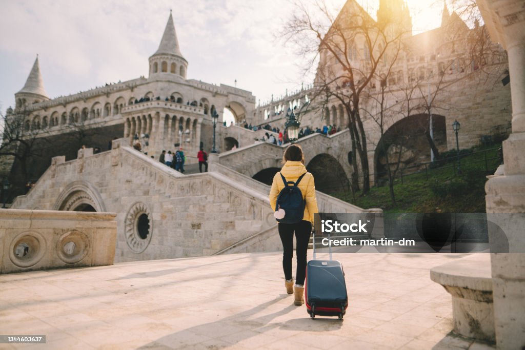 Tourist woman traveling solo in Europe Young woman with suitcase in Budapest Fishermen's Bastion Stock Photo