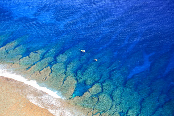 кристаллайн голубые воды лагуны острова западного реюньона, пляж с белым песком и сен-жиль сити - reunion стоковые фото и изображения