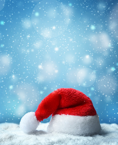 Santa claus hat with snow and blue snowfall background.