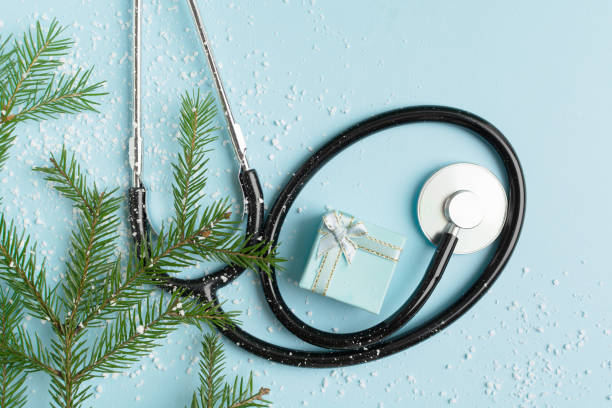 istock Christmas medical concept with stethoscope, gift box and christmas tree on blue 1344610062
