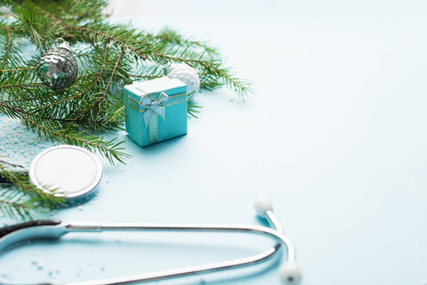 istock Christmas medical concept with stethoscope, gift box and christmas tree on blue 1344610138