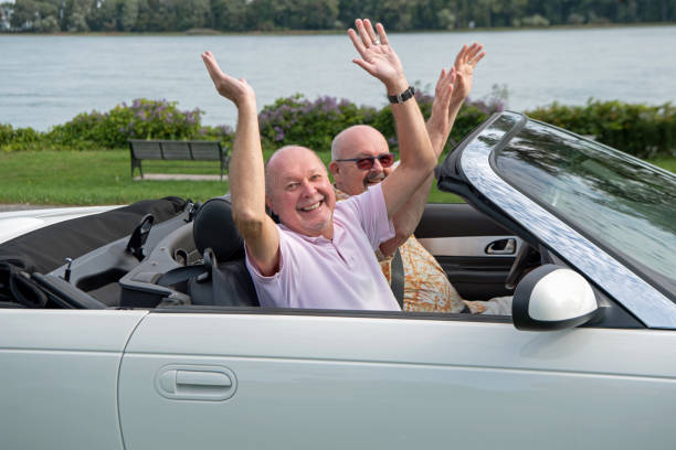 istock Married gay couple in their white convertible. 1344615568