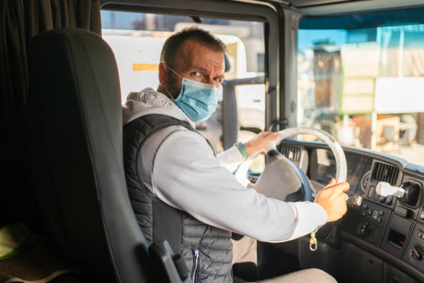 istock Truck driver wearing a facemask inside a truck 1344617071