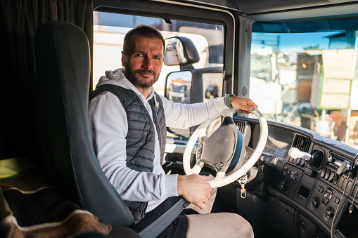 Truck driver wearing a facemask inside a truck