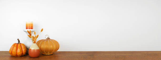istock Autumn decor on a wood shelf against a white wall banner background 1344617301