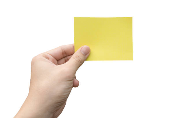 istock Hand holding yellow paper isolated on white 1344617412