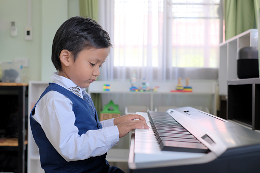 Boy playing synthesizer at home