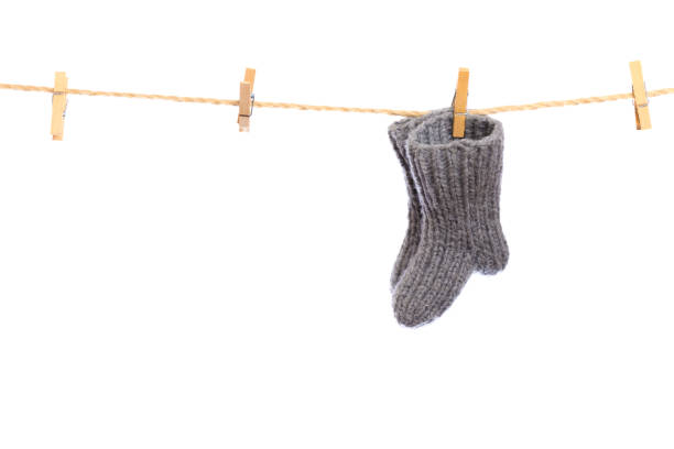 istock Baby clothes on a clothesline on white  background . knitted socks- Image 1344618266