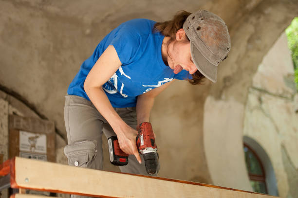 istock Skilled young female worker is using power screwdriver drilling during construction wooden bench gender equality, feminism, do it yourself concepts 1344621035