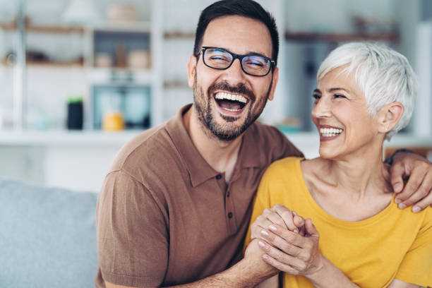 Happy mother looking at her adult son stock photo