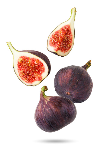 Figs falling whole and half close-up on a white background. Isolated