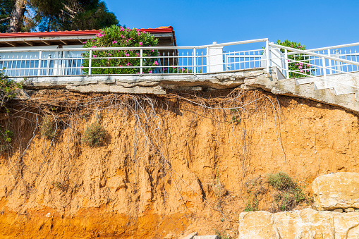 03.10.2021. Greece.  Nea Potidaea. Beautiful view of house with white metal fence on cliff edge.