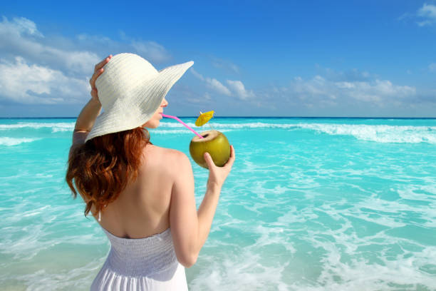 coconut fresh cocktail profile beach woman drinking stock photo