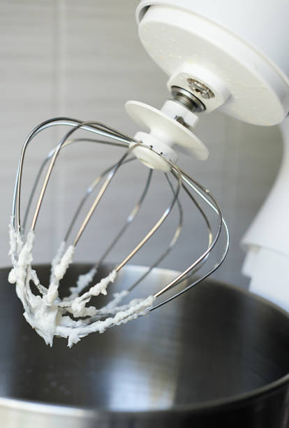 istock Whipped egg whites or frosting on electric mixer whisk. Baking dessert concept. vertical size 1344624127