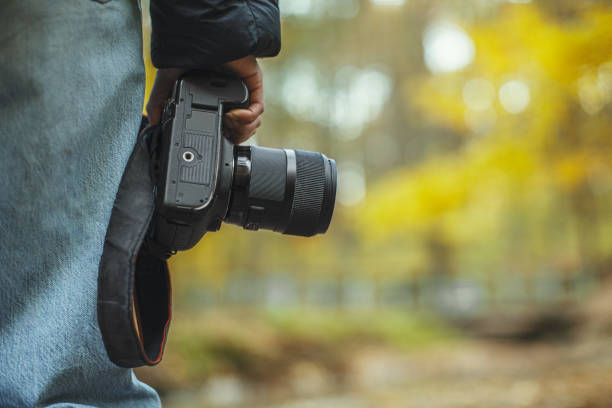 istock dslr camera in hand over blurred forest background 1344625060