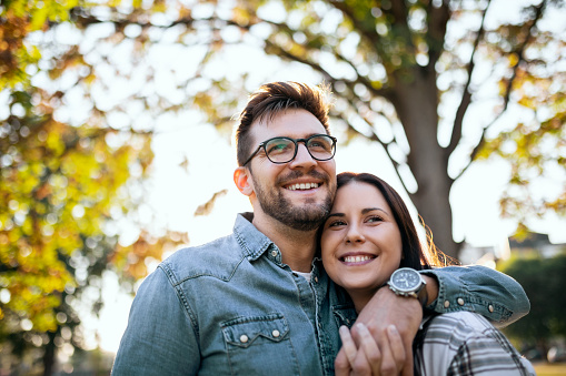 Young Couple in Love is Walking in Public Park and Enjoys an Autumn sunny day