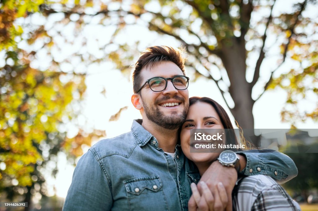 Young Couple and Autumn sunny day Young Couple in Love is Walking in Public Park and Enjoys an Autumn sunny day Couple - Relationship Stock Photo