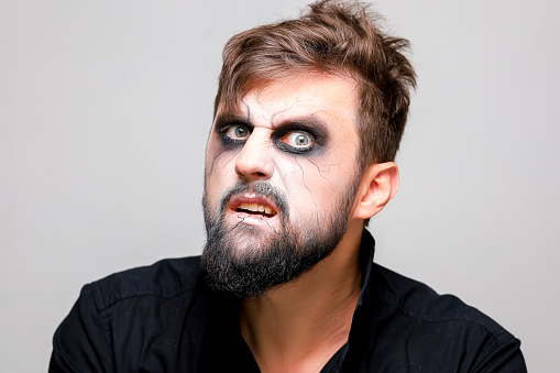 close-up portrait of a man with a beard with makeup for Halloween in the style of the undead