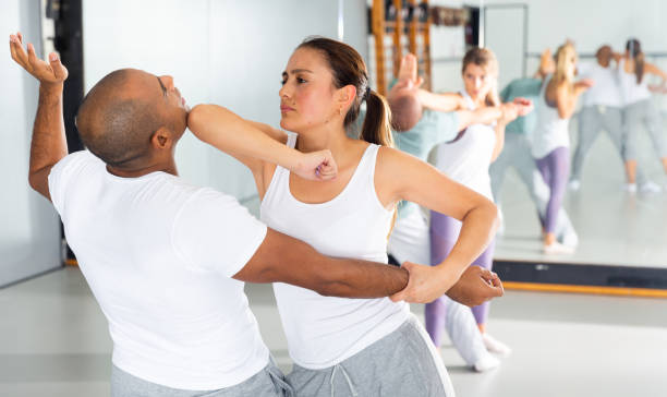 istock Young Latina practicing elbow hit in close combat with male partner 1344633768