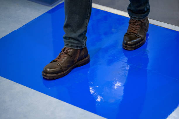 Man in brown shoes stepping on blue Adhesive Sticky Mats.