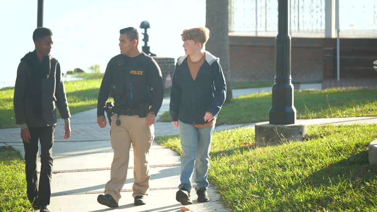 Friendly police officer walking with two teenage boys