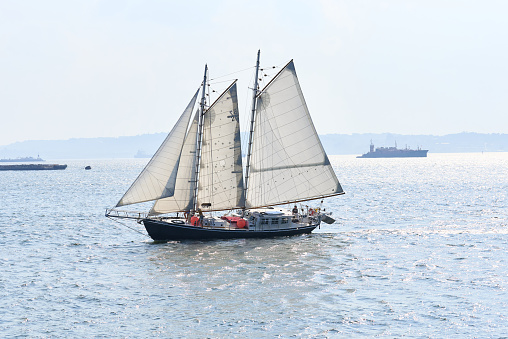 New York, NY - August 26, 2021: Schooner Apollonia sails in NY Harbor with Staten Island in the background. A traditional 64-foot gaff-rigged sailboat, she carries cargo from the Hudson Valley to New York Harbor.