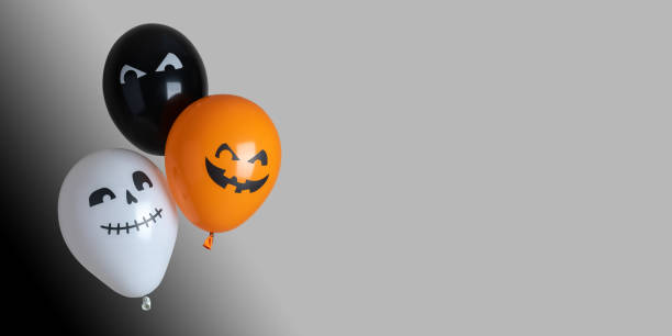 istock Orange, black and white halloween balloons on gray background 1344642690
