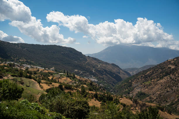 istock Poqueira Valley under a cloudy blue sky 1344645120