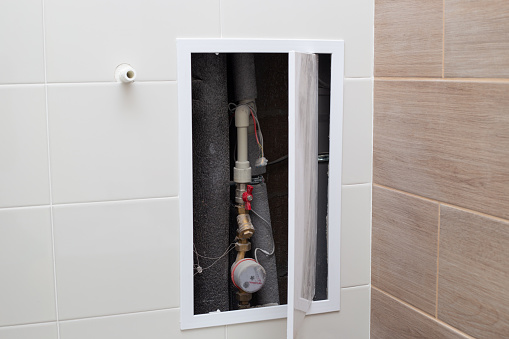 Bathroom wall hatch with pipes and water meter. Transmission of water meter readings.