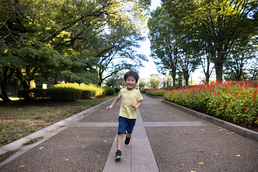 Little boy running in public park