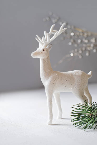 istock white shining decorative reindeer as christmas symbol. vertical size. evening light. xmas eve concept. Greeting card for new year party. Festive holiday. 1344649255