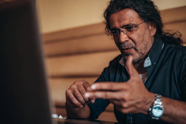 istock Senior hispanic cuban men using a laptop for an online video call in a cafe 1344652603