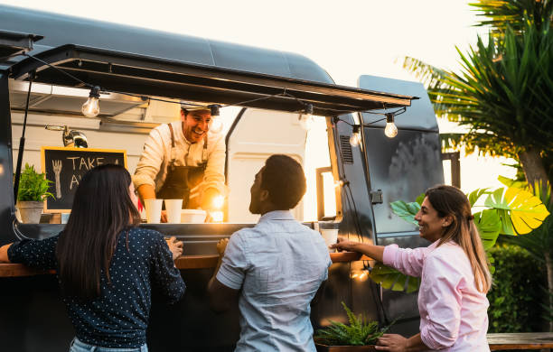 Young people buying meal from street food truck - Modern business and take away concept stock photo