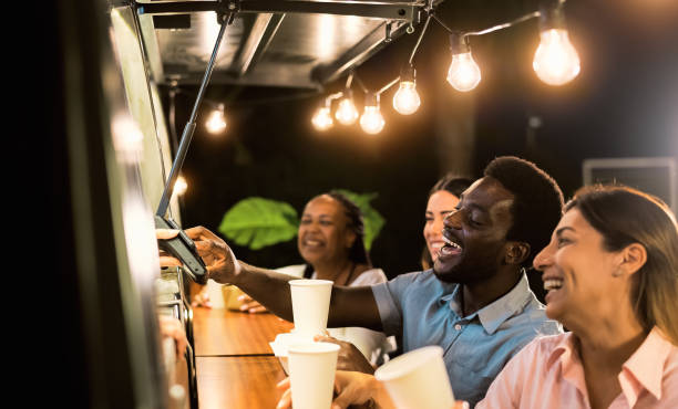 Happy multiracial people buying meal from food truck kitchen - Modern business and take away concept stock photo