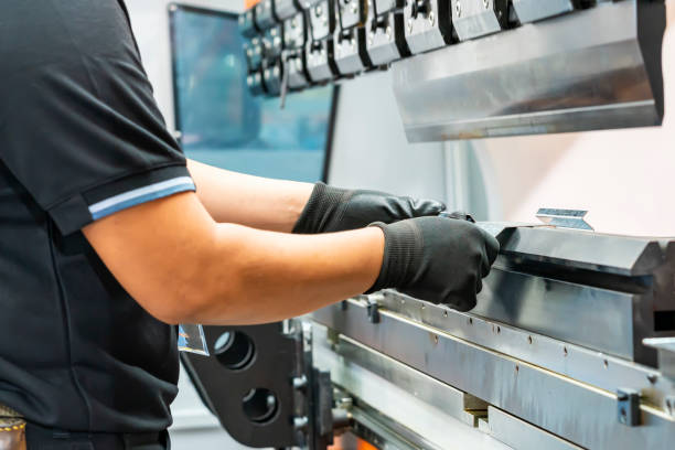 istock Close up teeth of the semi automatic hydraulic bending machine and the technician's hands catch the metal sheet or the workpiece during folding forming. 1344658877