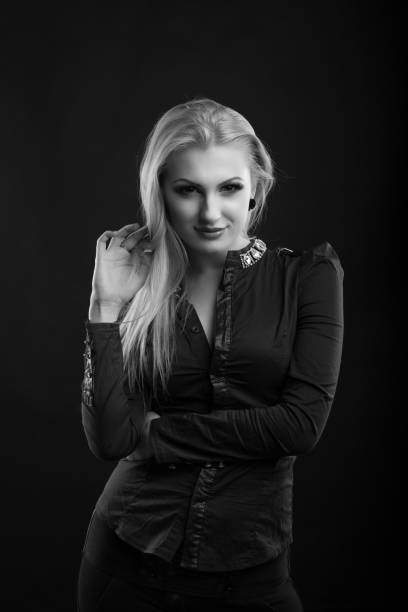 wonderful blond lady with perfect makeup and long straight hair wears blouse, posing at studio. black and white sho - studio sho imagens e fotografias de stock