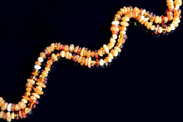 Necklace from natural amber on black background.