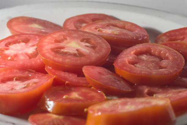 istock sliced tomato on a plate with white background, tomato slices texture. 1344674677