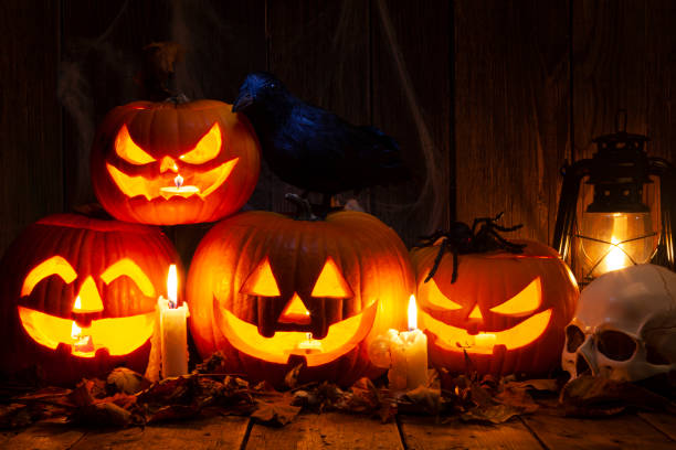 istock Halloween Jack-o-Lantern Pumpkins on rustic wooden background 1344674728