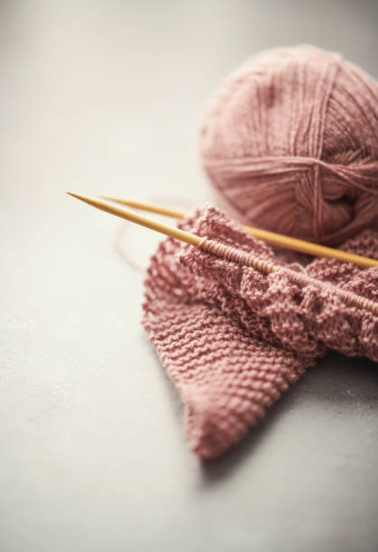 istock Pink Wool Being Knitted on Bamboo Knitting Needles 1344679930