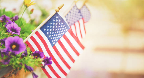 istock American Flags in Bright Warm Sunshine with Flowers 1344682687