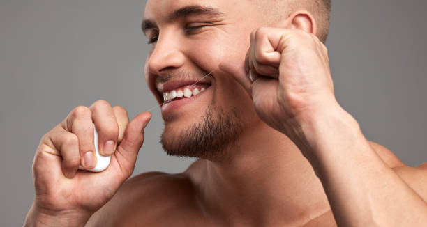 istock Studio shot of a handsome young man flossing his teeth against a grey background 1344683686