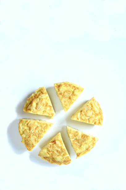 three spanish potato and onion tortilla slices on each other on a white background