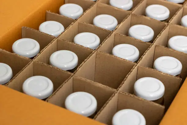 Photo of glass bottles in a cardboard box with partitions for transporting broken items.