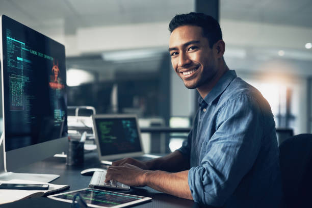 retrato de un hombre usando una computadora en una oficina moderna - profesional de informática fotografías e imágenes de stock