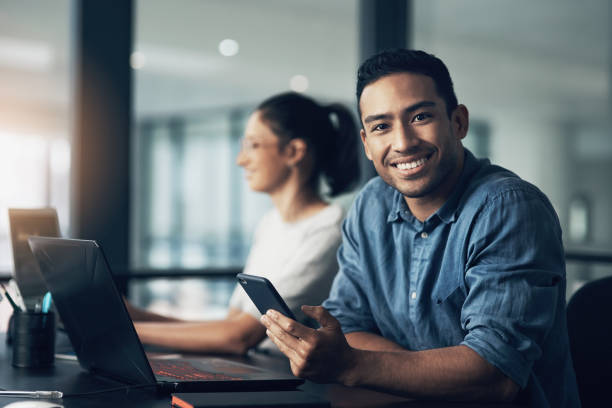 istock Portrait of a young man using a cellphone in a modern office 1344688165