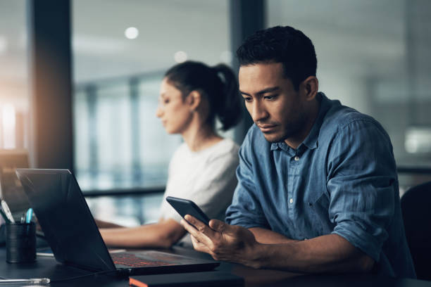 istock Shot of a young man using a cellphone in a modern office 1344688166