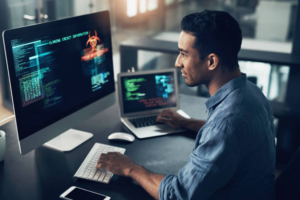 istock Shot of a young man using his laptop and computer in a modern office 1344688193