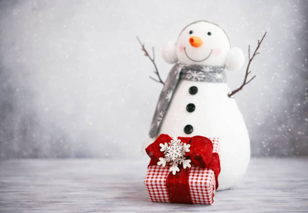 istock Cute Snowman with Gift against Snowy Background for Christmas 1344688252