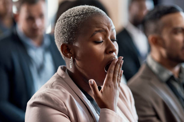 Shot of a an exhausted businesswoman yawning during a conference in a modern office Only thing I'm killing is time yawning stock pictures, royalty-free photos & images